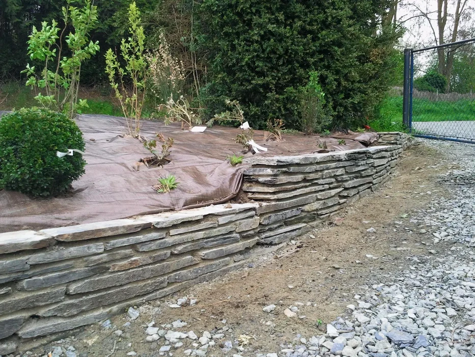 Jardin paysager méditerranéen avec allée courbe pavée en béton et briques rouges